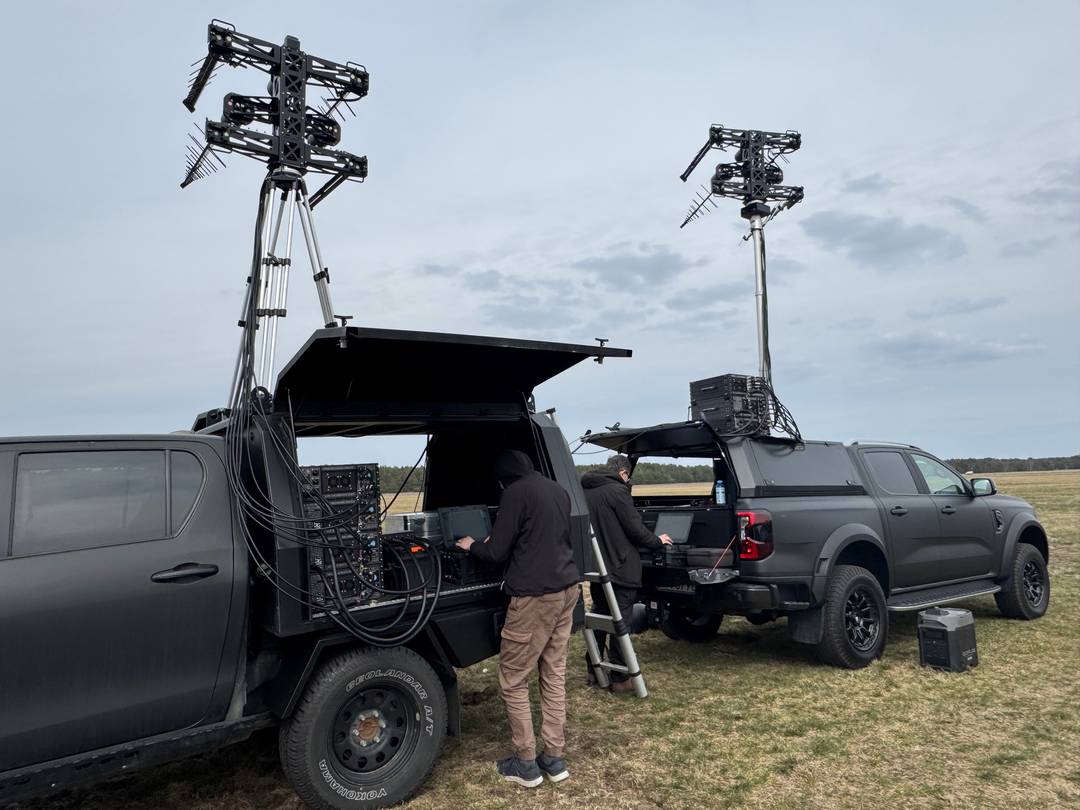 Two vehicle-mounted Defender jammer systems deployed in the field with operators — coordinated multi-vehicle counter-drone configuration